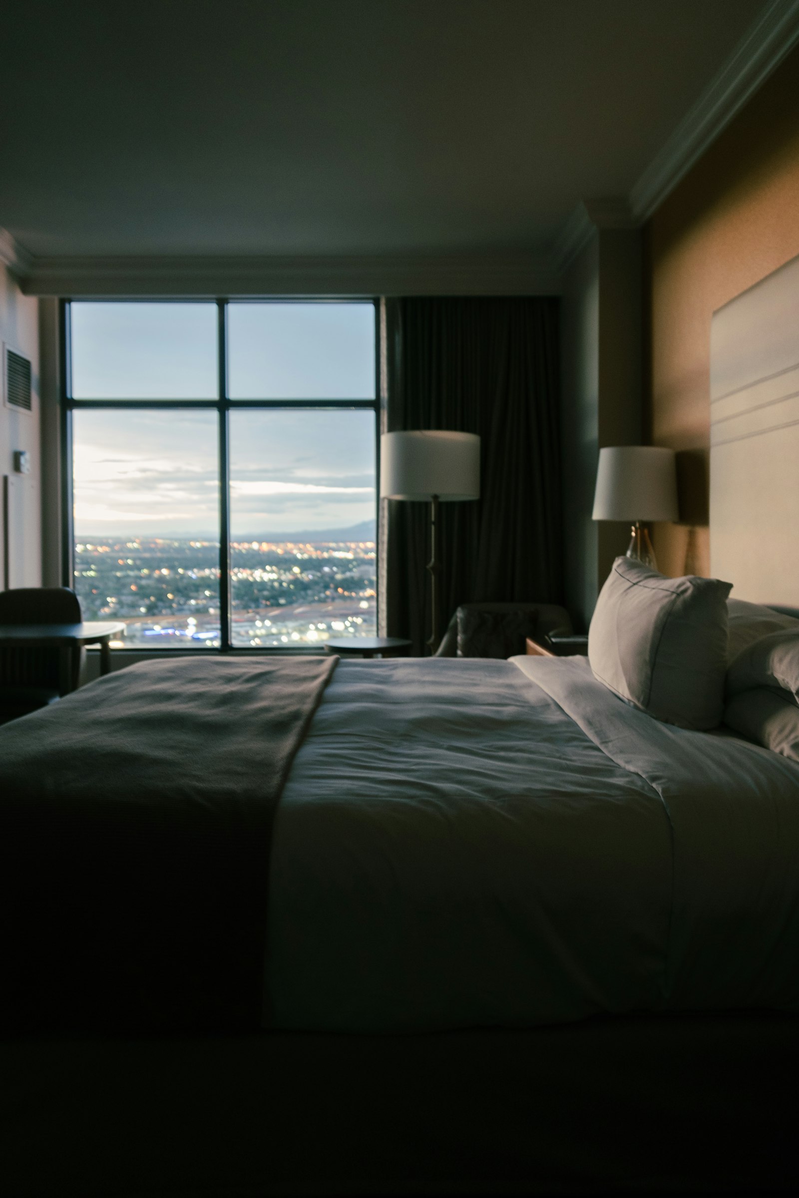 A hotel room at dusk, city lights beyond the window — The Sense Your Brand Keeps Forgetting